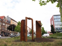 Metallskulptur im Verkehrskreisel Burbacher Stern, von Jugendlichen des städtischen Zentrums für Bildung und Beruf gGmbH (ZBB) unter der Leitung des Künstlers Wolfgang Raber entwickelt: Das dreiteilige Stahlkunstwerk verkörpert ein Tor und eine mehrstufige Treppe. Das Tor soll ausdrücken, dass die Türen und Tore für zukünftige Entwicklungen offenstehen - Man aber hindurchschreiten muss, was mit Anstrengungen verbunden ist. Die werden durch die angedeuteten Treppenstufen symbolisiert.