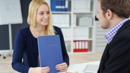 Frau mit Bewerbungsmappe im Bewerbungsgespräch