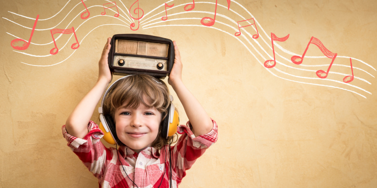 Kleiner Junge mit Kopfhörern hält ein Radio über dem Kopf aus dem Radio kommen Musiknoten