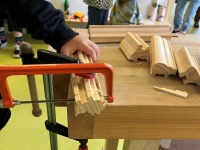 Mit einer Säge wird eine Holzfigur zugeschnitten