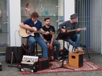 Drei Musiker mit Gitarren und Percussion