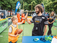 Ein Kind hält einen Football und klatscht ein Teammitglied der Toggo-Tour ab