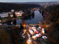 Blick von oben auf den Deutschmühlenweiher mit beleuchteten Ständen und der Seebühne