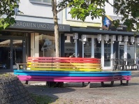 Die bunte Rundbank dient als Begegnungsort und symbolisiert die Akzeptanz verschiedener Lebensstile.  Mit der Regenbogenbank setzte die Landeshauptstadt in 2023 ein Signal für Akzeptanz und Vielfalt sowie gegen die Diskriminierung von Menschen mit den unterschiedlichsten sexuellen Orientierungen und Geschlechtsidentitäten.