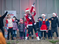 Sängerin im Weihnachtsmann-Outfit mit Kindern auf der Bühne der Konzertmuschel