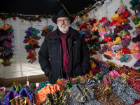 Verkäufer an seinem Stand mit Hausschuhen aus Wolle