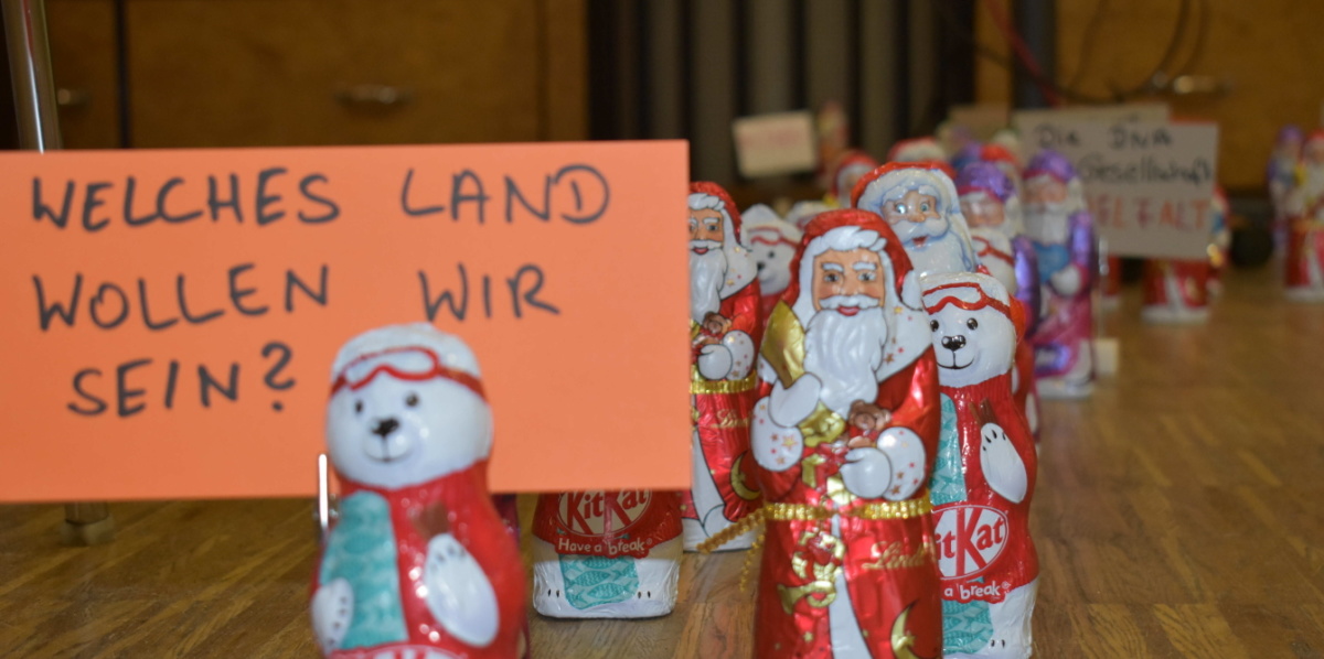 Schokoladennikoläuse tragen ein Schild mit der Aufschrift "Welches Land wollen wir sein?"