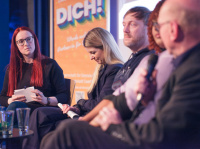 Menschen sprechen miteinander in einer Podiumsdiskussion